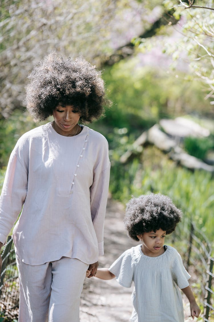 A Woman And A Young Girl Walking Together