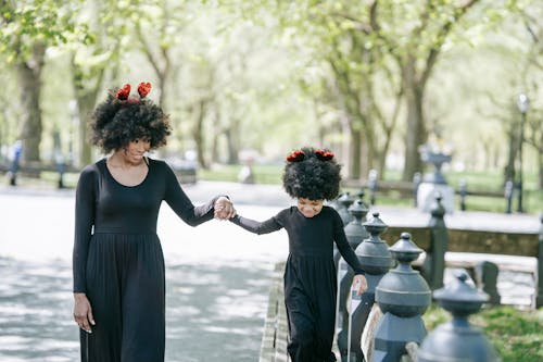 Free A Woman and a Young Girl Walking on the Park Stock Photo