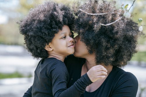 Free A Woman Kissing a Young Girl Stock Photo