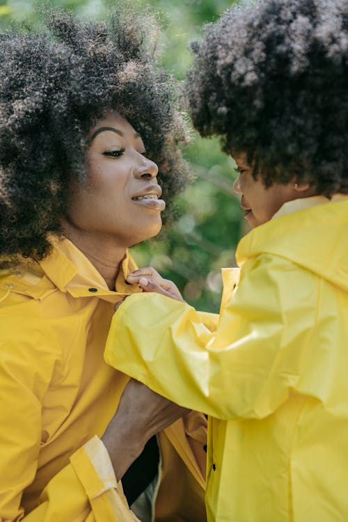 Foto profissional grátis de cabelo afro, capa de chuva amarela, criança