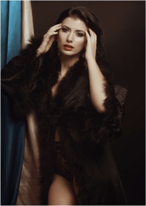 Free A model posing gracefully in dark lingerie and fur coat, exuding elegance and sensuality. Stock Photo