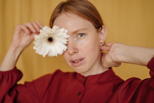 Free Close-up of a Woman Covering her Eye with a Flower Stock Photo