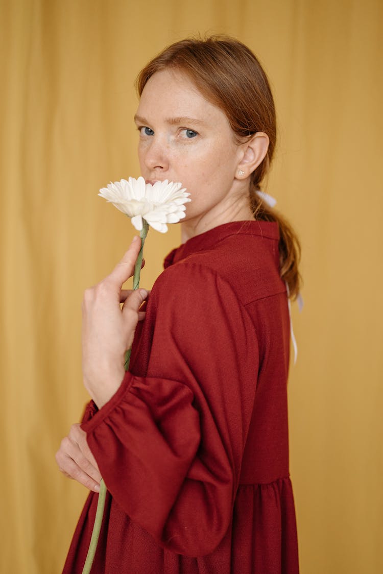 A Woman Holding A White Daisy Flower