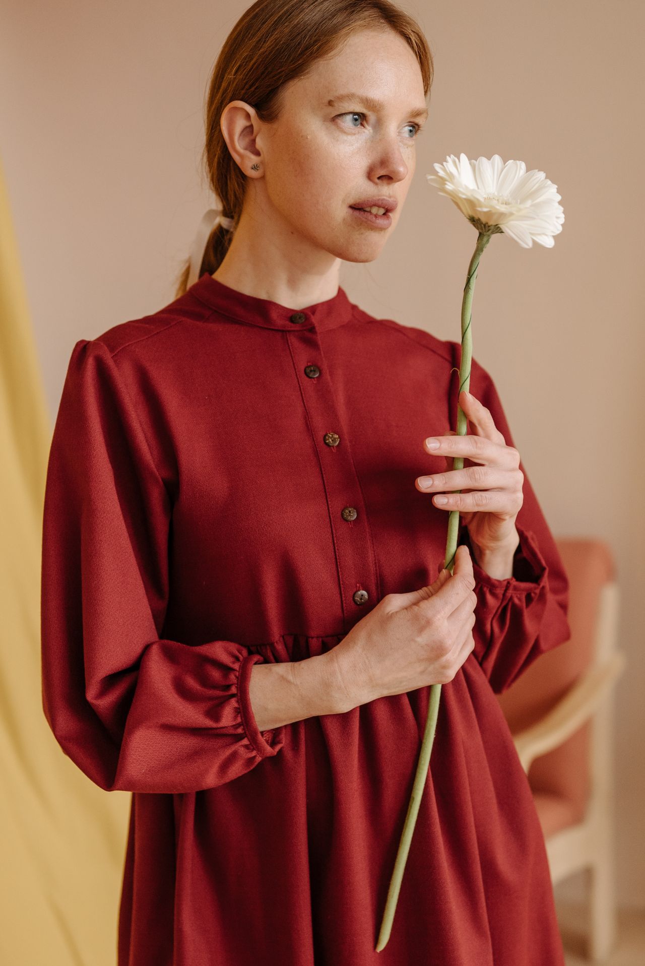 Woman wearing a modest burgundy button-front dress with long sleeves