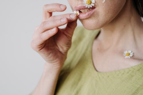 Close up of Woman with Daisy Petals around Mouth