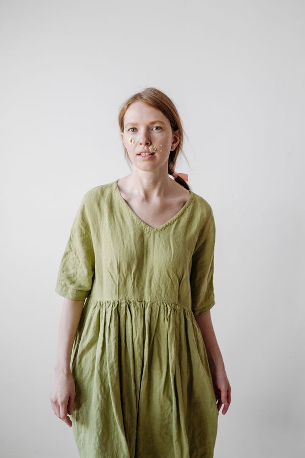 Woman wearing a sage green linen midi dress