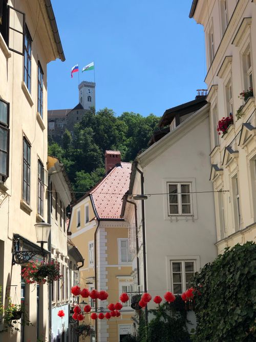 Free Scenic street in Ljubljana showcasing charming architecture with castle in background. Stock Photo
