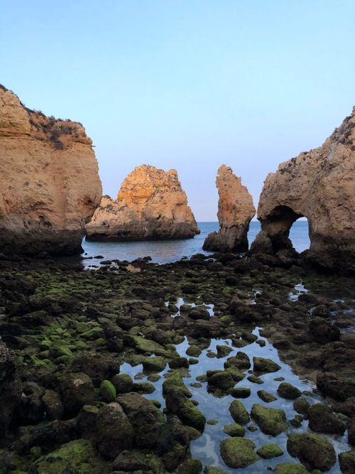 Free Beautiful rocky coastal formations against a serene sunset, reflecting calm and tranquility. Stock Photo