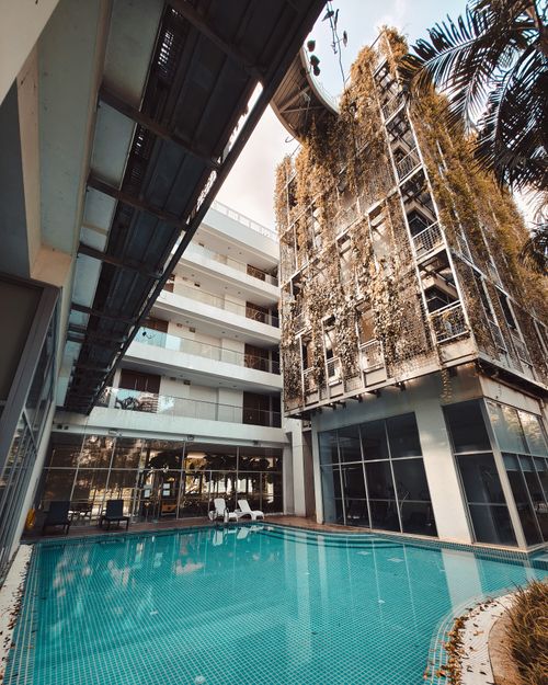 Free Contemporary hotel in Singapore featuring an outdoor pool and lush vertical greenery, capturing urban relaxation. Stock Photo