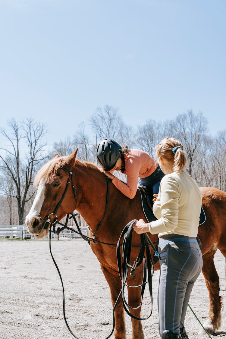 Woman Teaching Girl Horseback Riding