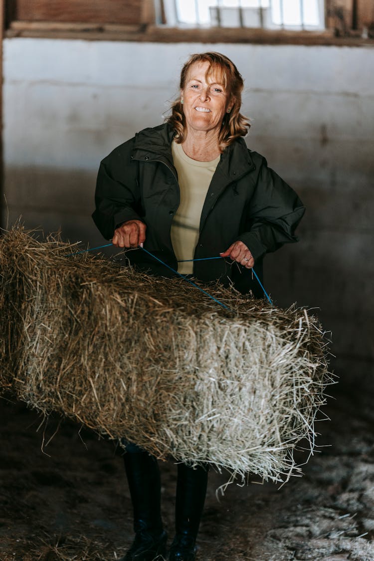 Woman Working In Stable With Hay