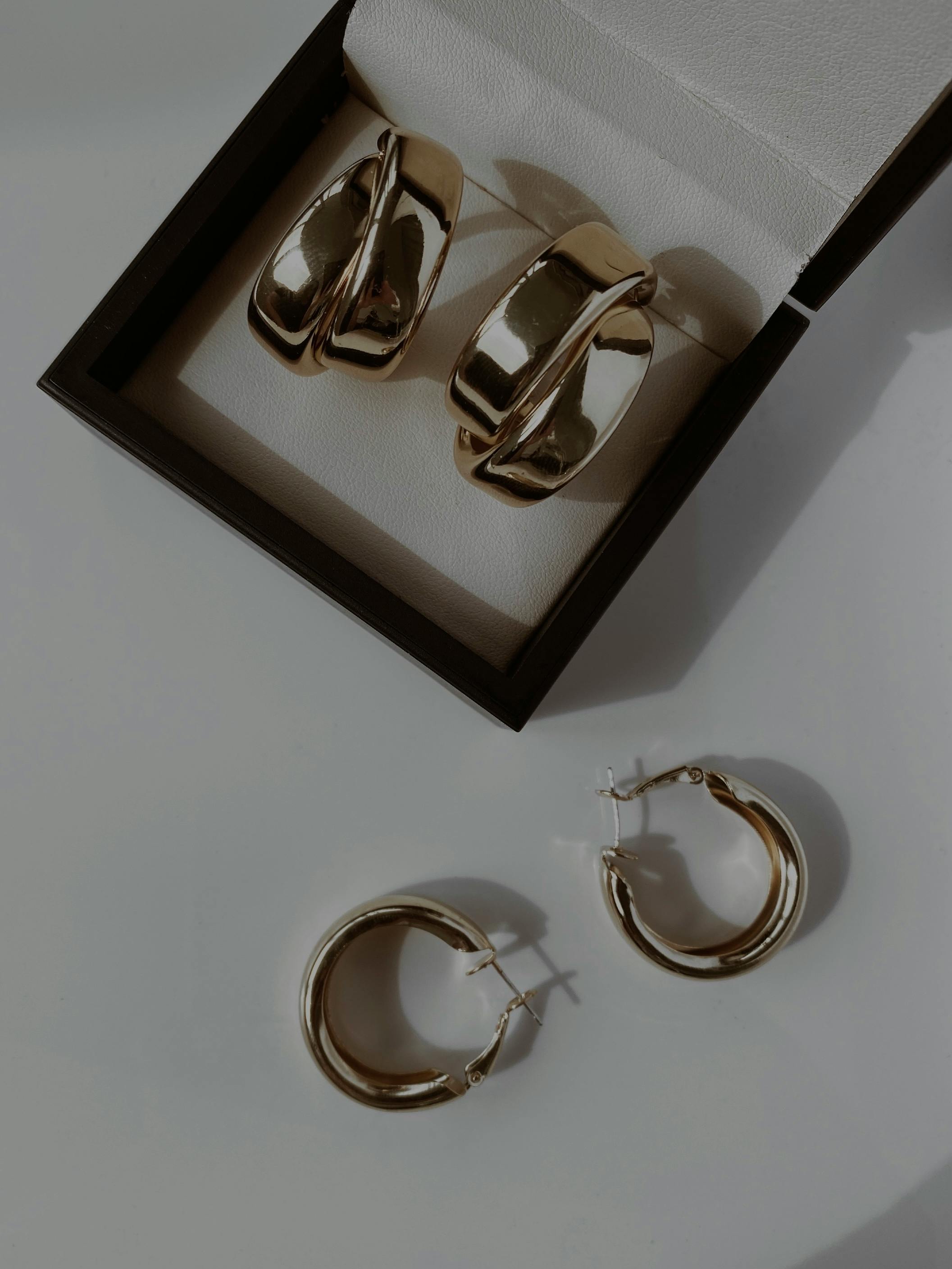 Stylish gold hoop earrings elegantly displayed in an open jewelry box, ideal for fashion enthusiasts.