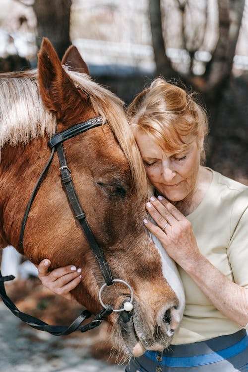 Senior Woman Holding Horses Head
