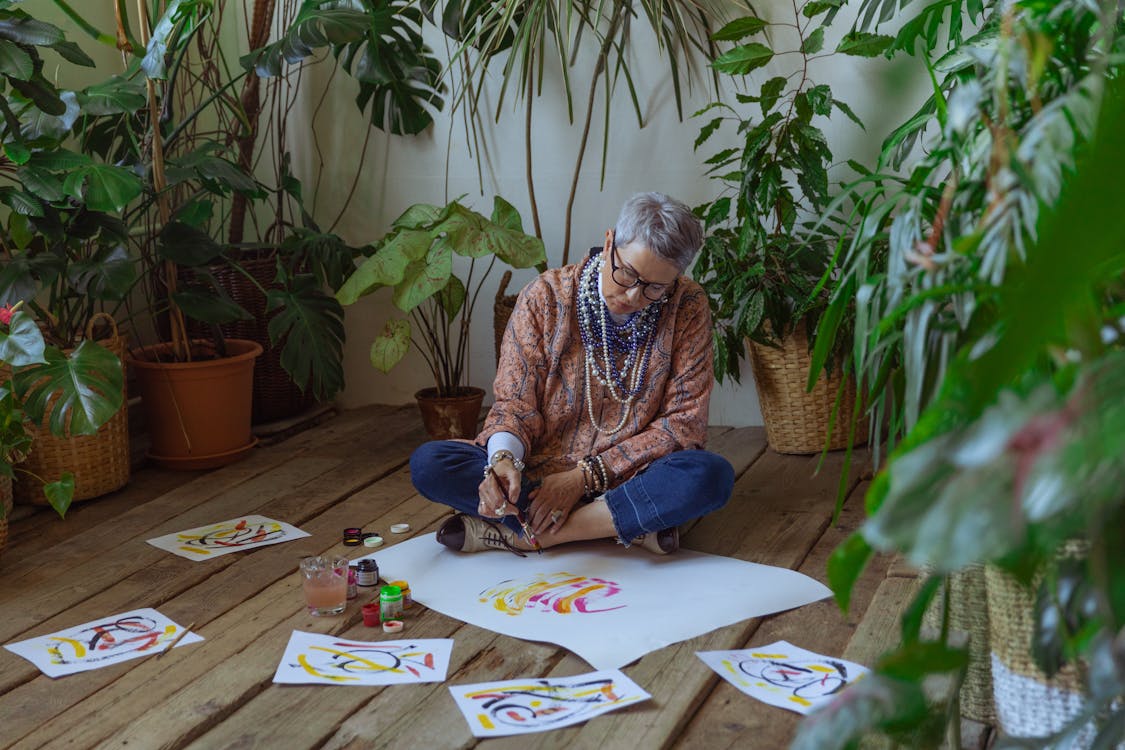 Photo Of Woman Sitting On Floor While Painting