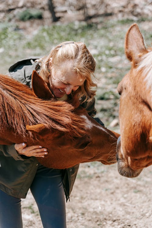Free A Woman Hugging a Brown Horse Stock Photo