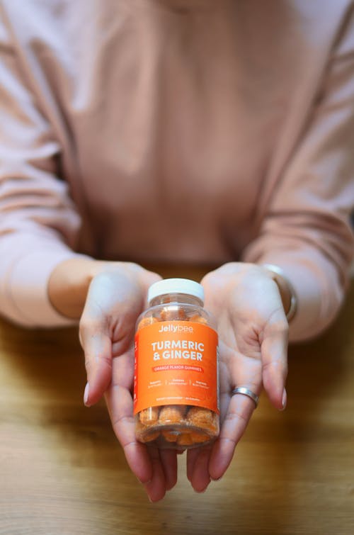 A Person Holding a Bottle of Turmeric and Ginger Gummies