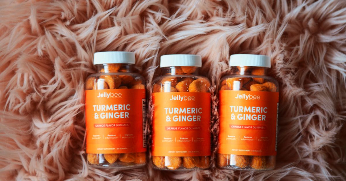 Bottles of orange turmeric and ginger gummies on a plush carpet, promoting health and wellness. - Evidence evidence guide for royal jelly immune support randomized trial