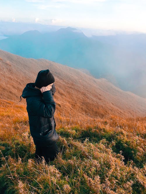 Free Man Wearing Black Jacket Standing On Grass Field Stock Photo