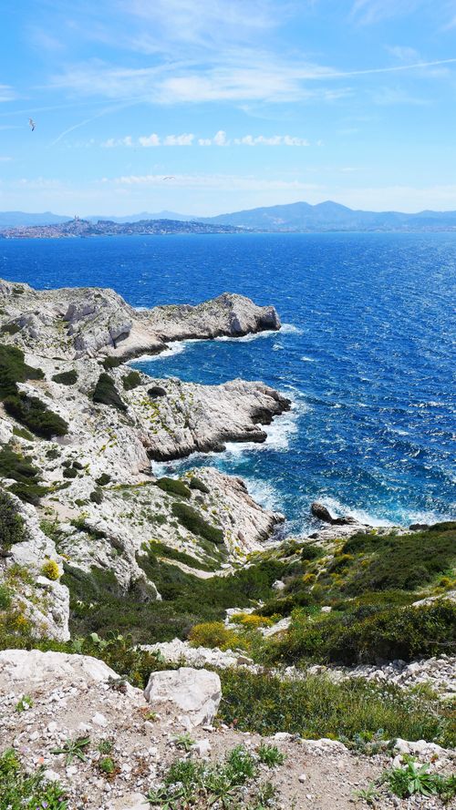 Free Breathtaking view of rocky cliffs and vibrant blue sea under a clear blue sky, perfect for travel inspiration. Stock Photo