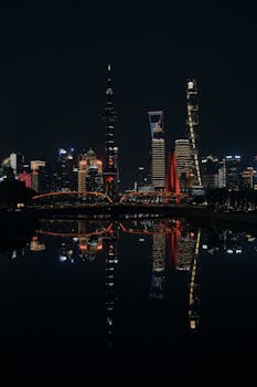 A breathtaking night view of the Shanghai skyline with illuminated skyscrapers reflected in the water.
