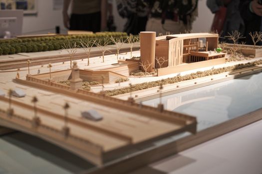 Detailed wooden architectural scale model displayed in an exhibition environment.