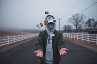 Person in Gray Hoodie Wearing White Mask