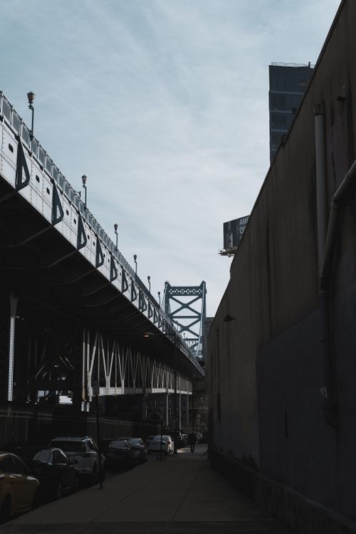 Free Moody cityscape showing bridge, street, and parked cars in muted tones. Stock Photo