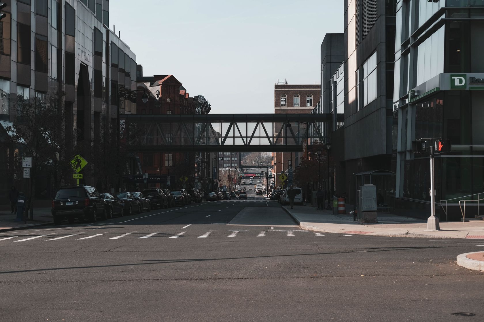 Street view of downtown Hartford, CT featuring modern and historic architecture with an overhead walkway.