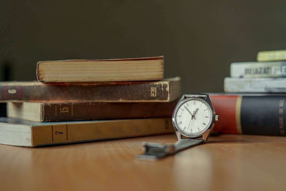 Silver Wristwatch Beside Books