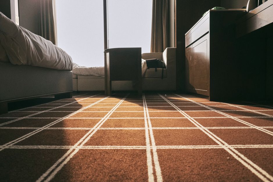 Gemütliches Schlafzimmer mit grauem Teppichboden und Holzmöbeln, passend für leisen Boden und Trittschallreduzierung im Altbau.