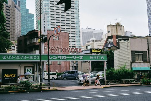 Street view featuring car rental signage with city buildings in the background.