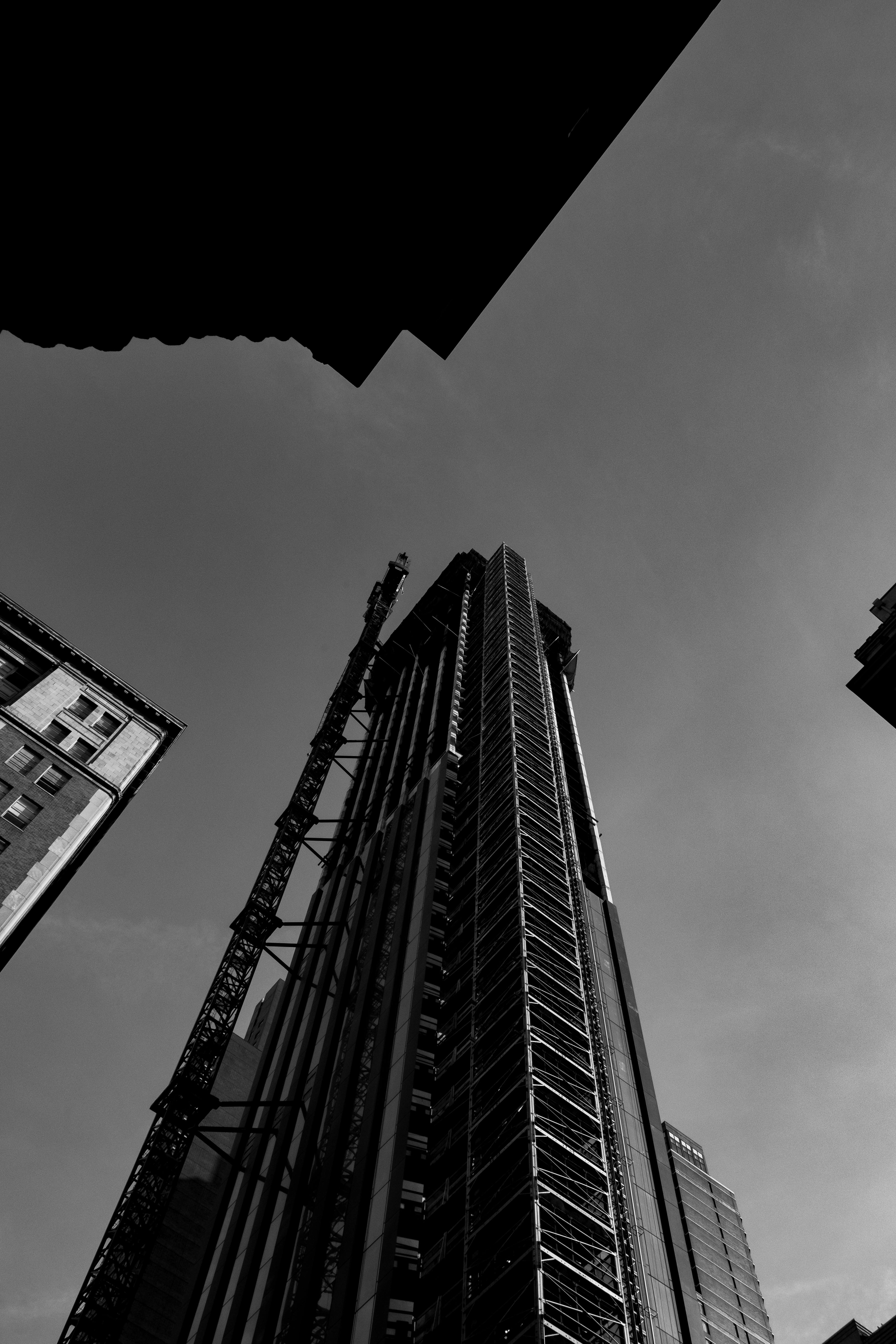 A striking black and white photo of a skyscraper captured from a low-angle.