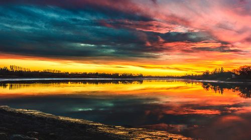 Free Vibrant sunset over a tranquil lake in Gimli, Canada, capturing the dramatic sky and reflections. Stock Photo