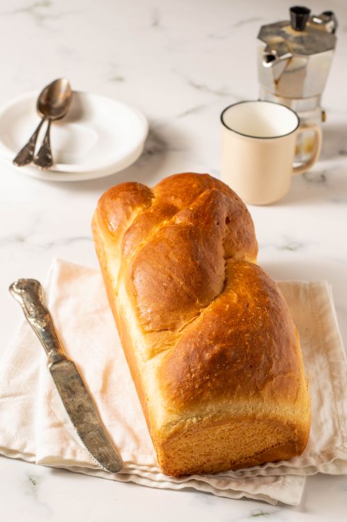 Free A beautifully baked homemade bread loaf on a kitchen table, perfect for breakfast settings. Stock Photo