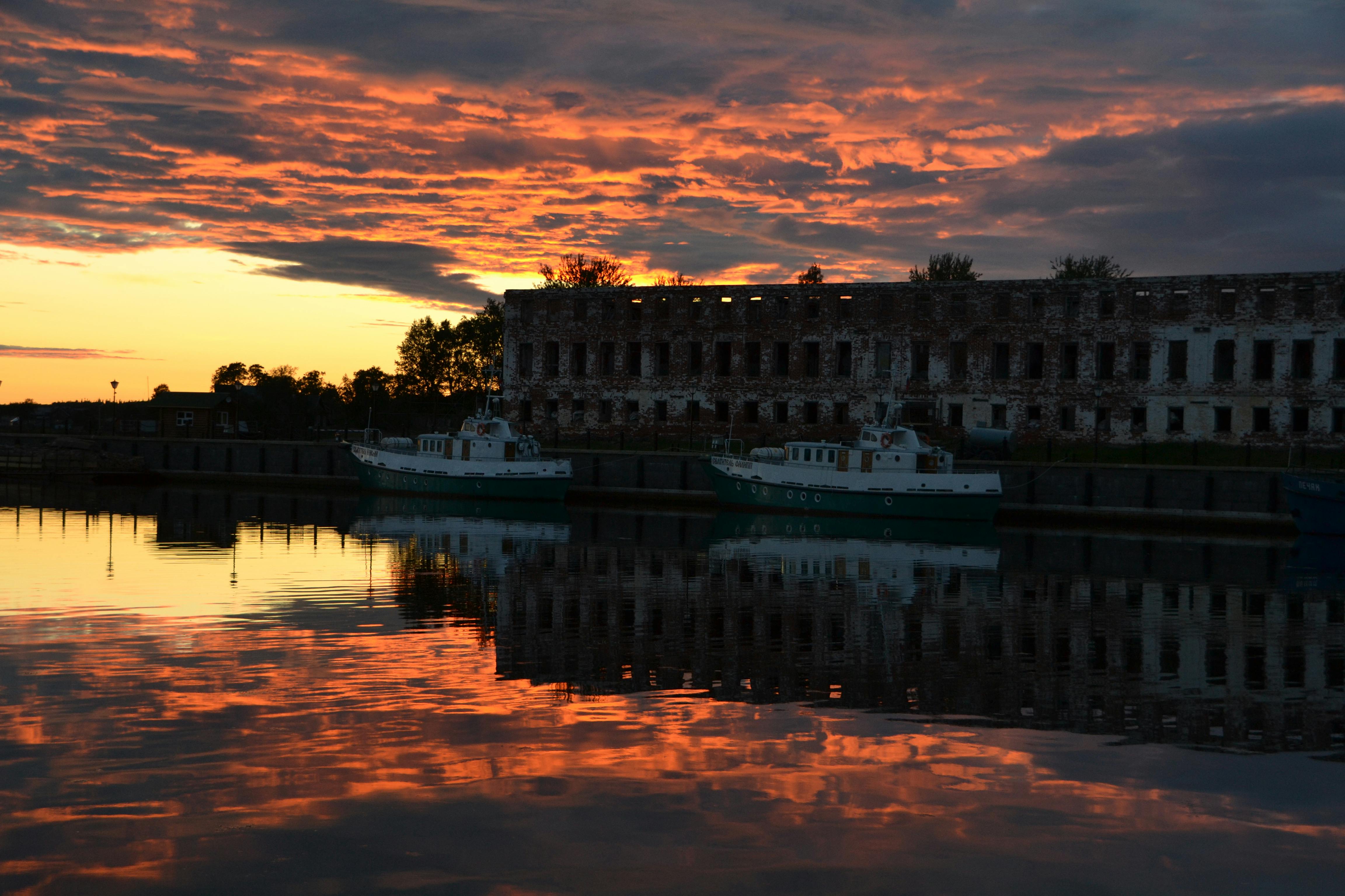 docked ferry near an abandoned building during dusk