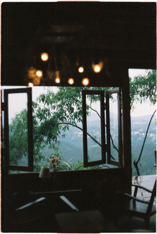 Free Cozy interior with open window offering a breathtaking view of mountains, blending indoor and outdoor aesthetics. Stock Photo