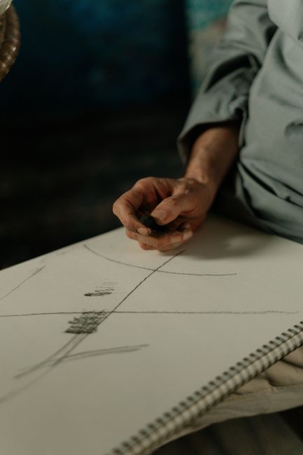 Detailed shot of an artist's hand creating a sketch on a blank page, emphasizing creativity and focus. Detailed shot of an artist's hand creating a sketch on a blank page, emphasizing creativity and focus.