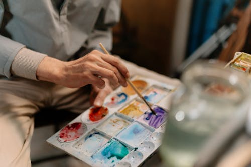 Man Mixing Paint On A Color Palette