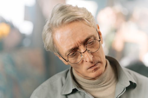 Photo of An Elderly Man Staring and Thinking