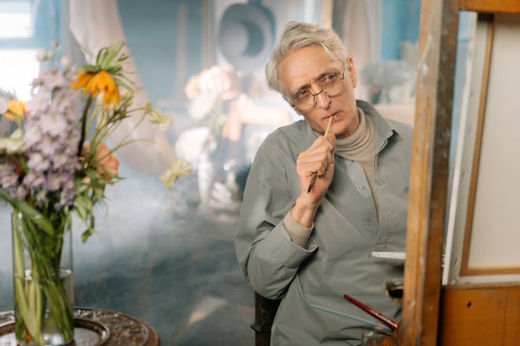 Elderly Man Biting A Paintbrush