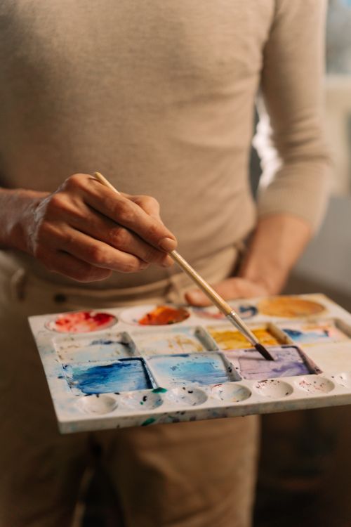 Free Close-up of an artist mixing vibrant colors on a palette, highlighting creativity. Stock Photo