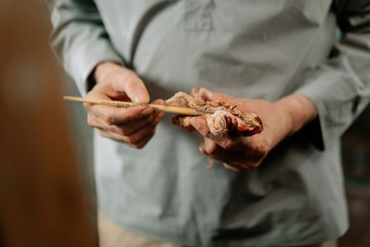 Close-up of an artist's hands holding a paintbrush and tissue paper, ideal for creativity themes.
