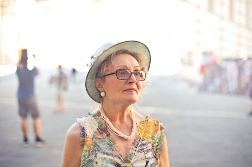 Free Depth of Field Photography of Woman in Pastel Color Sleeveless Shirt and White Sunhat Stock Photo