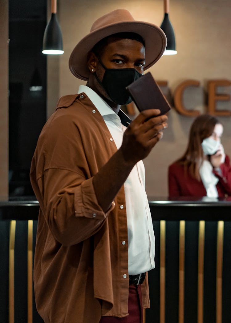 A Man Holding A Brown Wallet