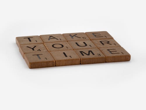 Brown Wooden Scrabble Tiles on White Surface