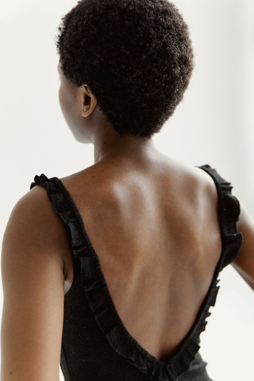 Free Back view of elegant woman in black dress, showcasing style and grace. Stock Photo