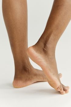 Detailed close-up of feet on a neutral background focusing on skin tone and texture.