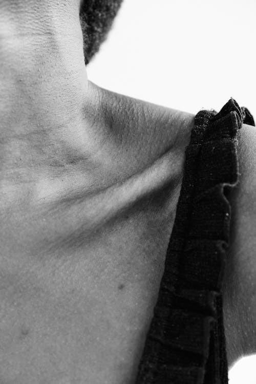 Grayscale Photo of Person's Collarbone