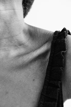Black and white close-up highlighting the texture of the collarbone area.