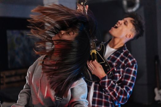 Two friends enjoying an intense Guitar Hero session, feeling the music.